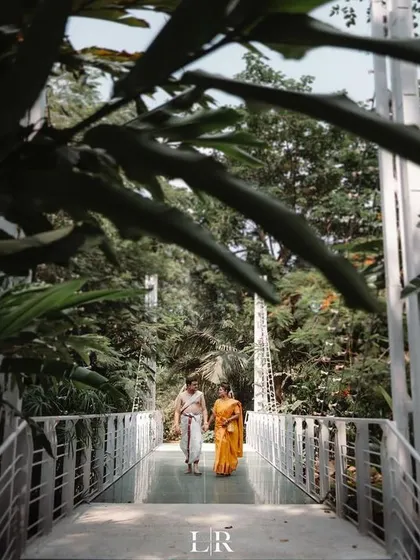A serene couple portrait on a bridge surrounded by lush greenery. We use natural landscapes to create beautiful and timeless images.