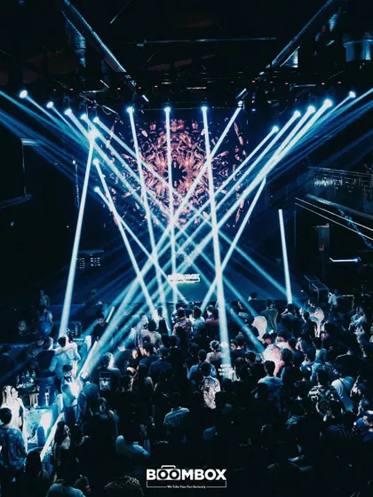 A web of blue lasers creating a mesmerizing effect over the packed club.