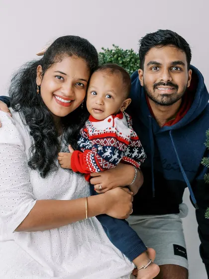 A family portrait with their baby in a festive sweater. A simple and sweet memory of their holiday together.