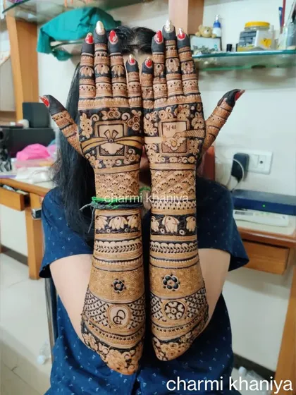 A complete bridal mehendi look, packed with details! This design includes everything from the couple's initials and wedding date to traditional symbols like elephants and lotuses.