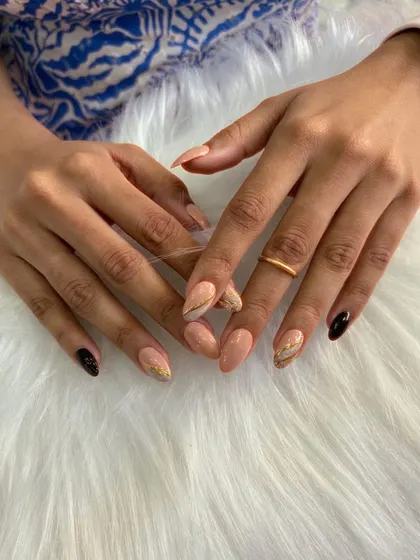 A chic and modern design featuring a mix of nude, black, and gold marble accent nails. This sophisticated combination is perfect for an elegant yet contemporary look.
