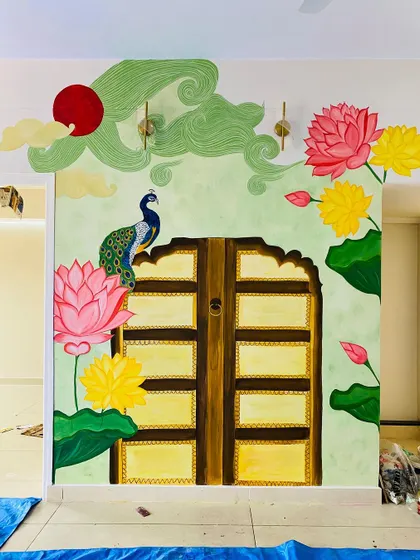 This traditional backdrop for a pooja mantap is one of our favorite projects. We worked closely with the client to bring together elements like the Jaipur-style door, vibrant Pichwai lotuses, and a proud peacock, creating a truly divine space.