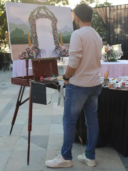 Vivek standing back to assess the composition of the painting. This is a crucial step to ensure the final piece is balanced and beautiful.