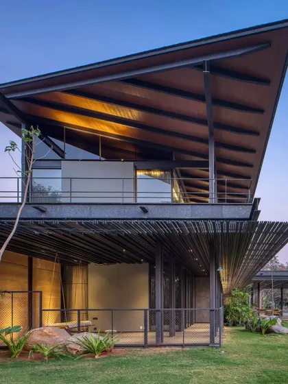 The completed Lakeshore house at dusk, a composition of rammed earth, metal, and glass. The architecture and the site must sing a duet, and this project is the beginning of that song.