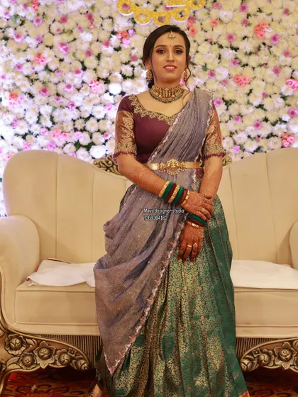 A client looking lovely in a green and grey half saree with a heavily embroidered purple blouse.