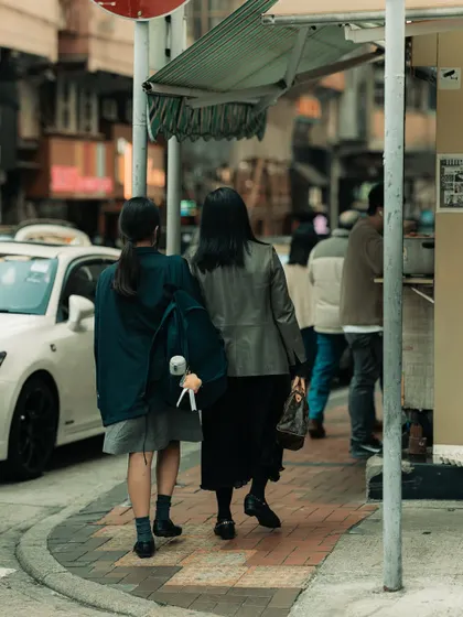 Two people walking down a street in Hong Kong. My street photography often focuses on the simple act of people moving through the city, each on their own journey.