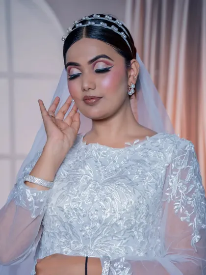 With eyes closed, you can see the delicate pink and white eyeshadow work, creating a soft and dreamy effect perfect for a church wedding.