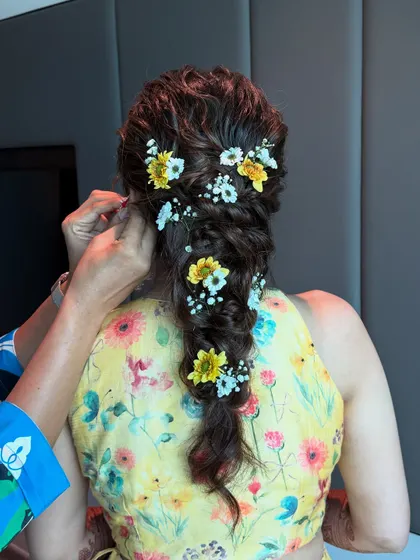 Another angle of the Haldi braid, showing the placement of the fresh flowers. This hairstyle is perfect for keeping hair off the face while still looking festive and beautiful.