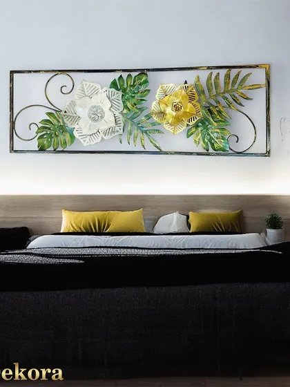 A framed floral piece with white and gold flowers and green leaves. The rectangular frame gives it a clean, contained look, perfect for above a headboard.