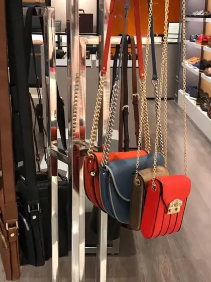 A freestanding circular rack for displaying hanging bags, a space-efficient solution for showcasing accessories.