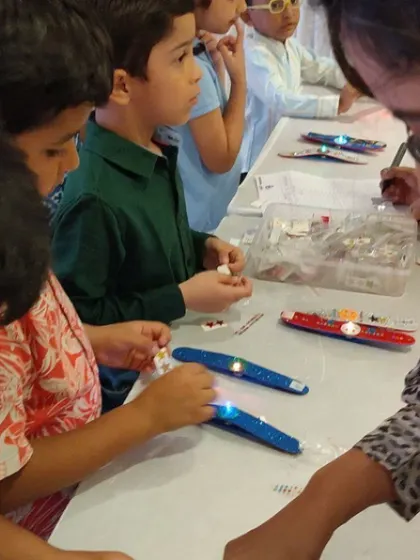 Kids work together to assemble their light-up wands, carefully connecting the LED lights to the power source with our guidance.