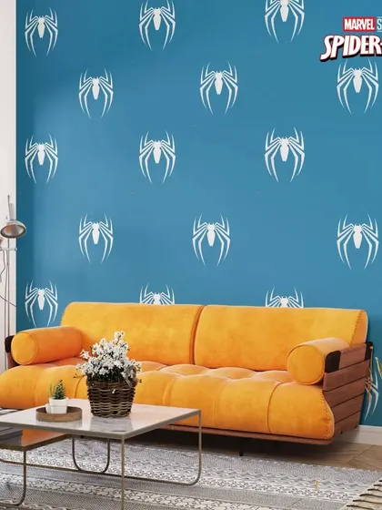 A repeating Spider-Man logo pattern on a blue wall creates a cool and immersive theme for a fan's bedroom or playroom.