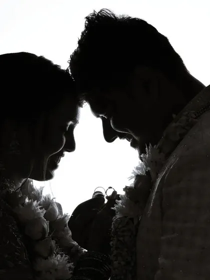 A beautiful silhouette of a couple touching foreheads, a simple yet powerful image of their connection.