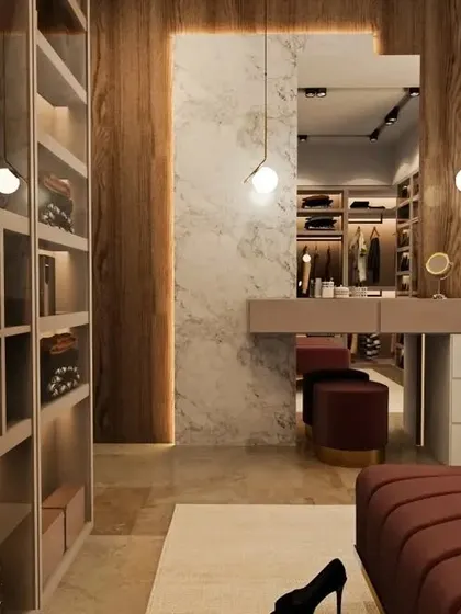 A spacious walk-in closet with a mix of open and closed storage. The design includes a large vanity and comfortable seating, making it a luxurious personal dressing room.