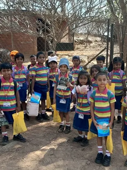 Students explore the natural surroundings at Jain Farm, observing animals like emus up close.