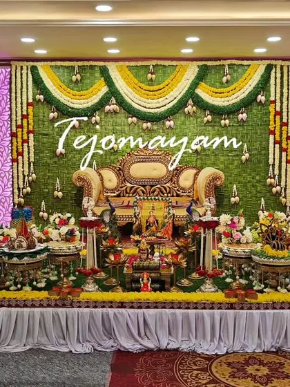 A beautiful baby shower setup with a backdrop of hanging green and white floral garlands, creating a serene and elegant atmosphere.