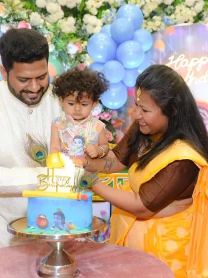 A candid moment of the family cutting the birthday cake together.