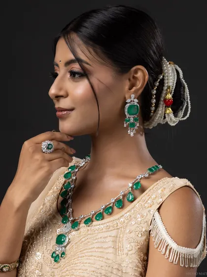A classic profile portrait, showcasing the full set of emerald bridal jewellery.