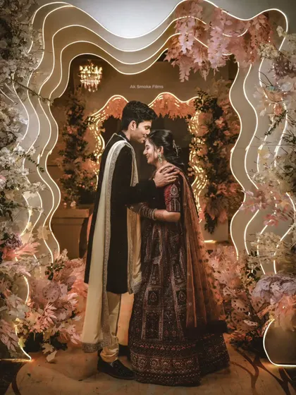 A tender moment between a couple at their reception, framed by a stunning modern floral archway.