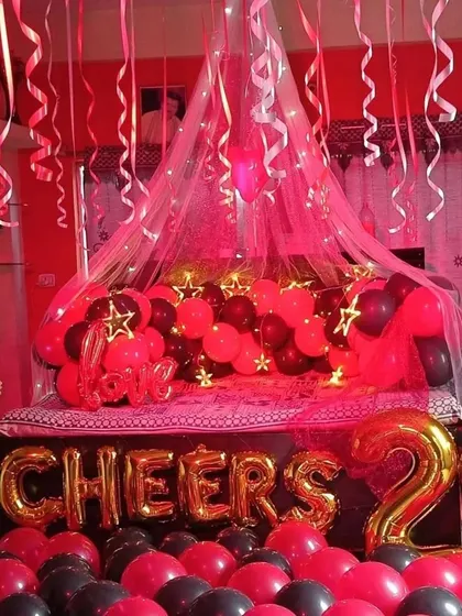 Another view of the popular red and black 'Cheers' decoration. This setup is perfect for milestone birthdays or anniversaries, creating a very celebratory and photo-ready room.
