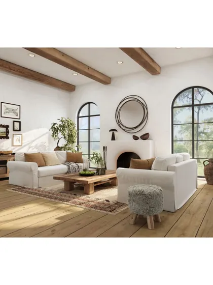 A rustic-modern living room featuring exposed wooden ceiling beams, arched windows, and comfortable white sofas. This design blends natural elements with clean aesthetics to create a warm and inviting family space.