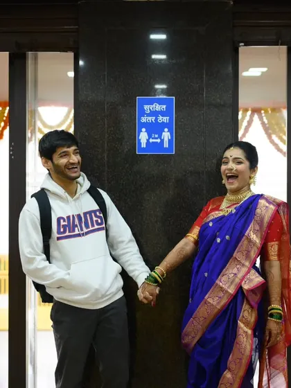 I love it when couples bring their own brand of humor to the wedding day. Sanika was all ready for her portraits, but Shubhankar showed up in a hoodie. The "Surakshit Antar Theva" sign was just too perfect. It’s these funny, real life moments that tell your unique love story.