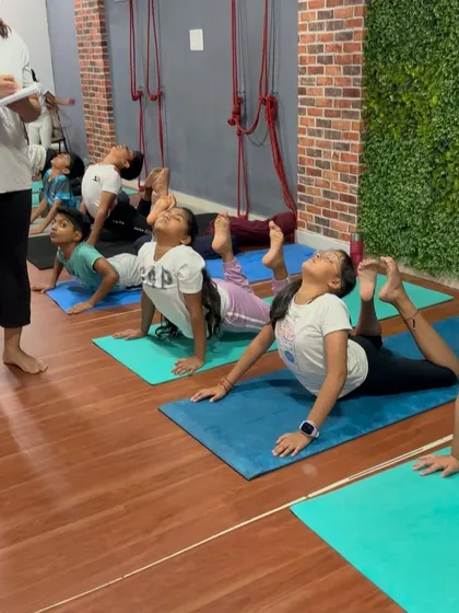 A line of students in Bhujangasana (Cobra Pose), a foundational backbend that strengthens the spine and opens the chest.