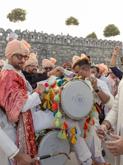 The guests and family join in the celebration, dancing to the beat of the dhol in a joyous and colorful procession.