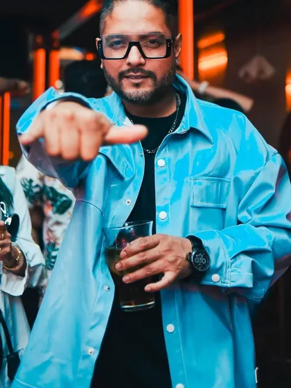 A cool, confident pose with a drink in hand. This is my 'off-duty' look, still ready for a party.