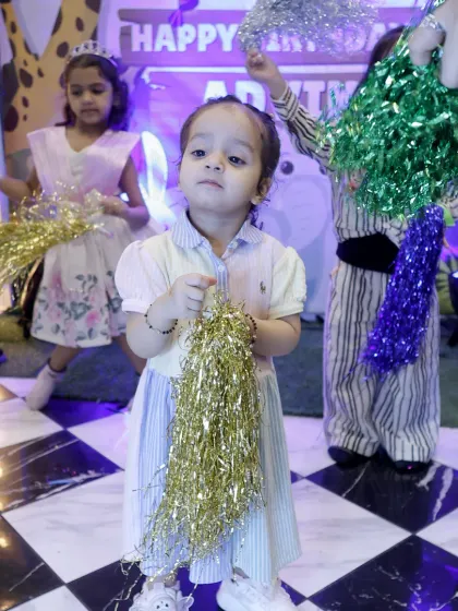 A little one enjoys the party with her pom-poms. We provide fun props to get everyone into the dancing and celebratory spirit.