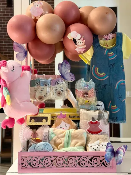 A bundle of joy for a little princess, this baby girl hamper is all things pink and pretty. It includes a denim jumper, soft toys, rattles, and other essentials, all beautifully arranged in a decorative tray.