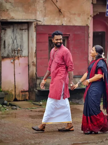 A candid pre-wedding shot of a couple walking through the charming old streets of Udupi, capturing a slice of local life.
