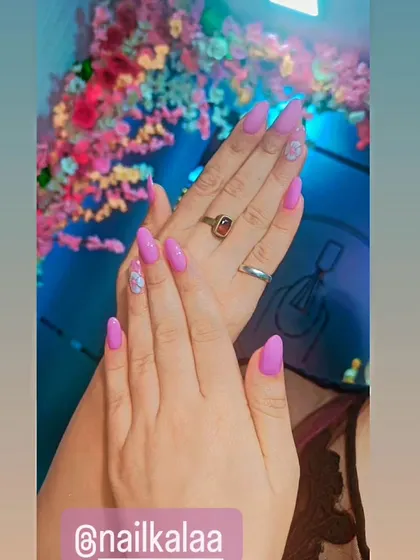 A pretty pastel purple manicure with delicate floral accent nails. This is a soft and feminine look perfect for spring.