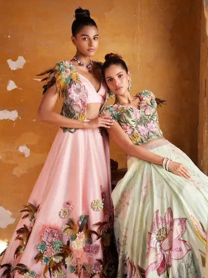 This is for the bride who wants a touch of drama. These lehengas feature 3D floral and feather appliqué on the shoulders, creating a high-fashion, memorable look.