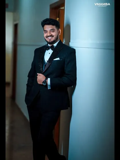 A stylish groom portrait in a hallway, using the leading lines of the corridor to create a dynamic and interesting composition.