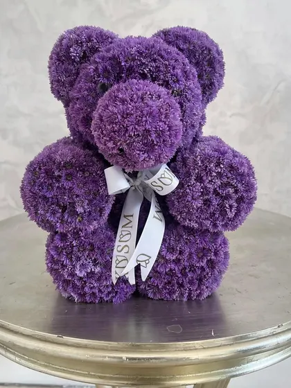 My floral teddy bears can be customized in a variety of colors. This charming bear is made from fluffy purple chrysanthemums and finished with a satin ribbon, making it a wonderful gift for a birthday or baby announcement.