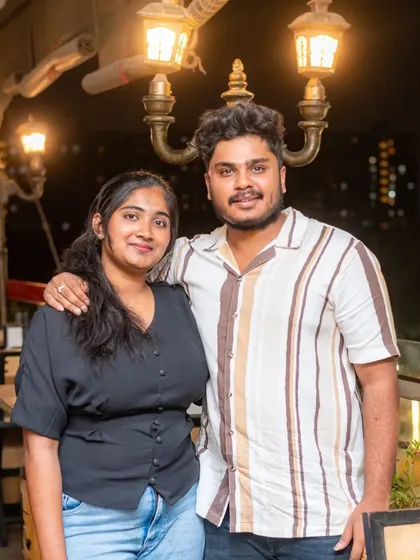 A couple enjoying the warm lighting of the rooftop area.