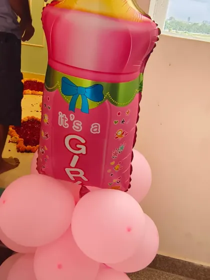 A cute balloon pillar featuring an "It's a Girl" milk bottle foil balloon. This is a great decorative element to place at the entrance or inside the home for a welcome party.