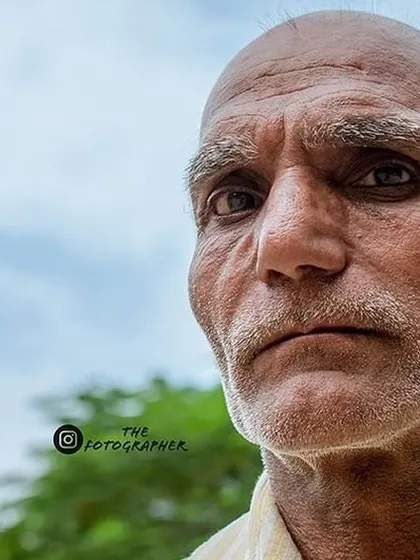 This is another angle from the same street portrait session. The slightly off-center composition and the soft background help to emphasize his weathered features and steady gaze.