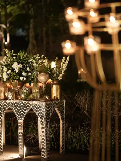 A beautiful composition of an inlay console table, floral arrangements, and a modern candle stand, showcasing our eye for detail.