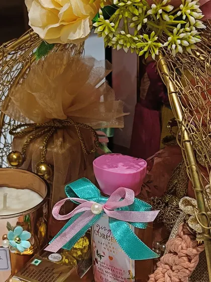 A macro shot of the wedding hamper, highlighting the scented candle, body mist, and other small luxuries tied with pretty ribbons.