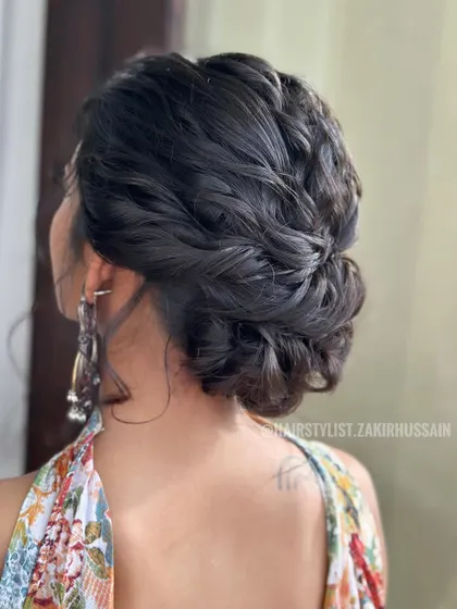 A textured and braided updo that is both elegant and modern. The style is perfect for a floral-themed outfit.