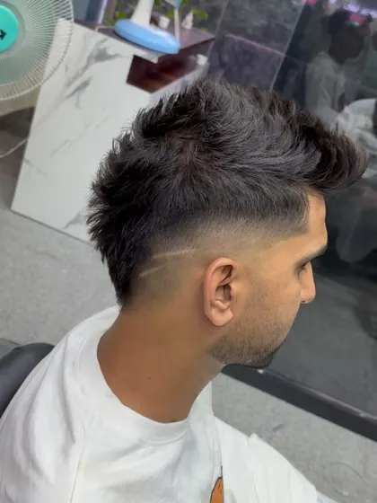A mohawk with a fade and a line design.
