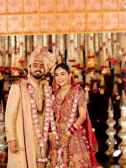 The couple poses for a portrait after their varmala ceremony. The backdrop of flowers and cold pyro effects creates a sparkling, celebratory frame for this beautiful moment.