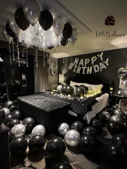 For a sleek and modern celebration, I used a black, silver, and white palette. The balloons are arranged around the chandelier and across the room, with fairy lights on the bed adding a warm, intimate glow.