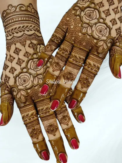 A beautiful rose jaal (net) pattern, where the flowers and vines create a delicate mesh across the back of the hand.