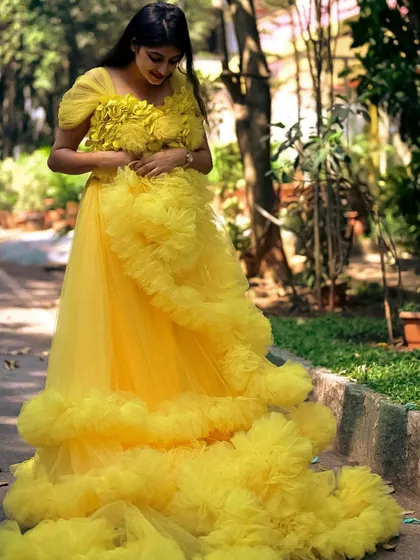 Our yellow ruffle gown is like a ray of sunshine. The floral details on the bodice and the cascading ruffles make it a cheerful and beautiful choice for any photoshoot.