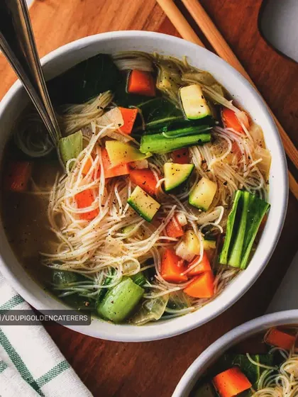Our vegetable noodle soup is a light and healthy option, featuring thin rice noodles and chunky, fresh vegetables in a clear, savory broth.