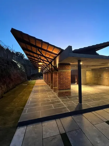 A site visit to the 'Club Cove' project, a community club for a villa development. The design features a dramatic folded roof and a material palette of brick, stone, and steel.
