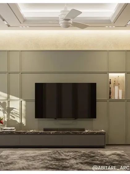 This television and media unit is designed to be both functional and a beautiful feature of the room. The soft green paneling, marble countertop, and integrated backlighting create a clean, organized, and aesthetically pleasing focal point.